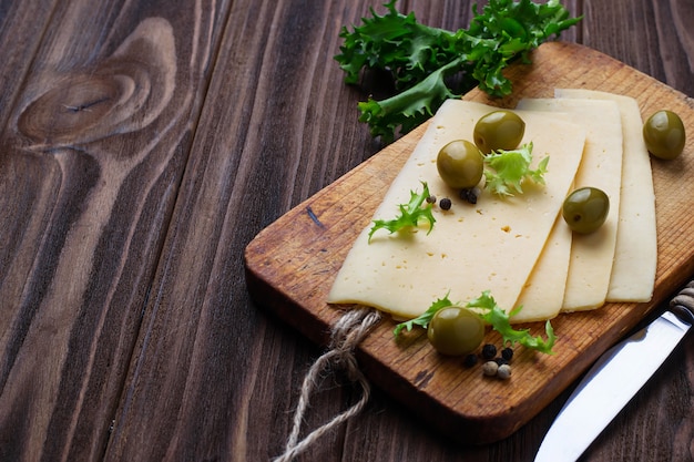 Rodajas de queso y aceitunas verdes.