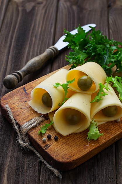 Rodajas de queso y aceitunas verdes.