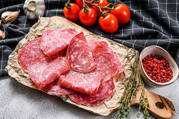 Rodajas de salami ahumado crudo. Fondo gris