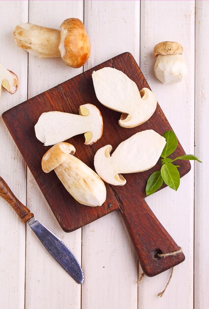 Rodajas de setas blancas sobre una plancha de madera