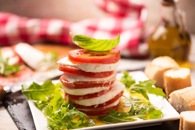 Rodajas de tomate y mozzarella con hojas de albahaca