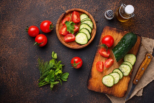 Rodajas de tomate y pepino en tabla de cortar