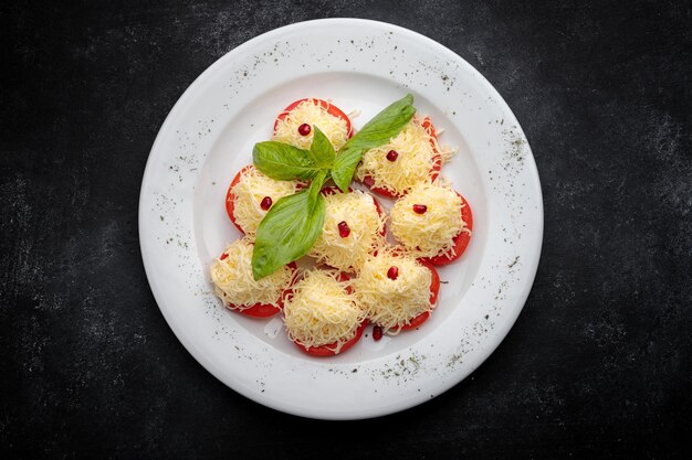 Rodajas de tomate con queso y mayonesa en un plato