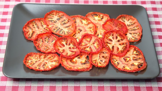 Rodajas de tomate seco en un plato. Alimento vegetal con vitamina