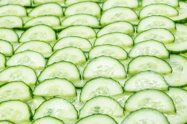 Foto rodajas verdes frescas de pepino como fondo. vista superior.