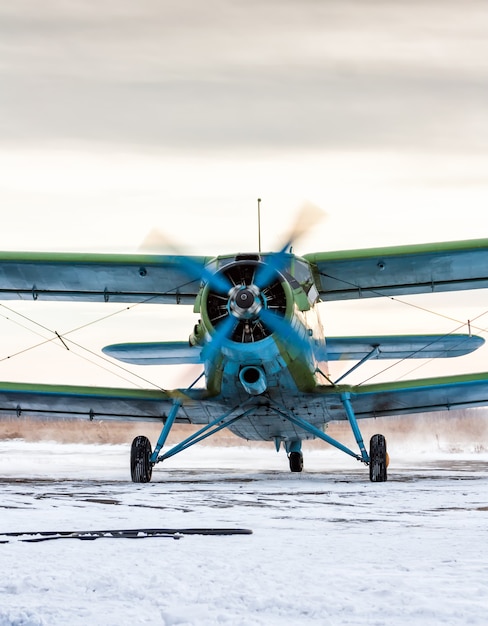 Foto rodaje de un biplano monomotor en un frío día de invierno