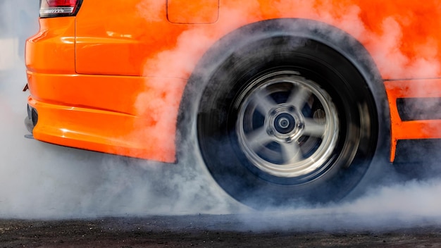 Foto rodas de carro queimadas pneus com fumaça branca rodas de automóvel queimadas com fumo do pneu giratório rodas de carros de arrastão queimados pneus preparação para a corrida