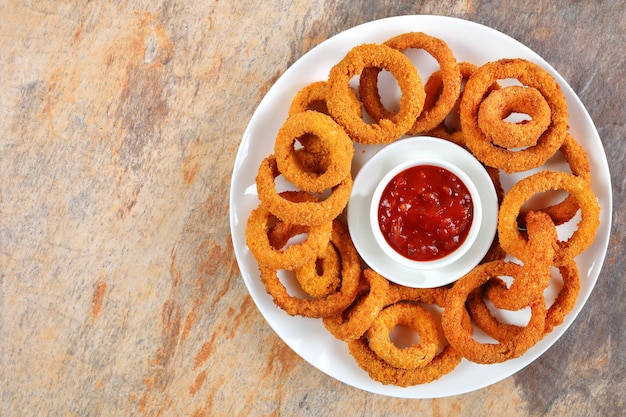 rodelas de cebola frita servidas com ketchup