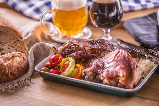 Rodilla bávara tradicional eslovaco checo alemán y deliciosa comida austriaca. Carne de cerdo asada ahumada con cerveza de barril.