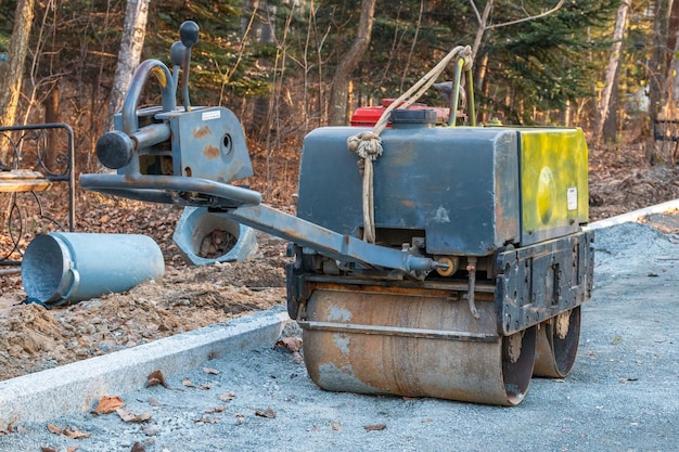 Rodillo de asfalto compacto manual para apisonar el suelo en un sitio de construcción en un parque público.