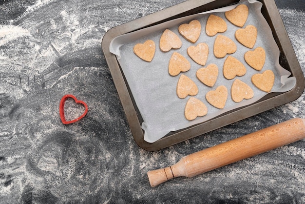 Rodillo de madera y bandeja para hornear con galletas en forma de corazón Repostería casera