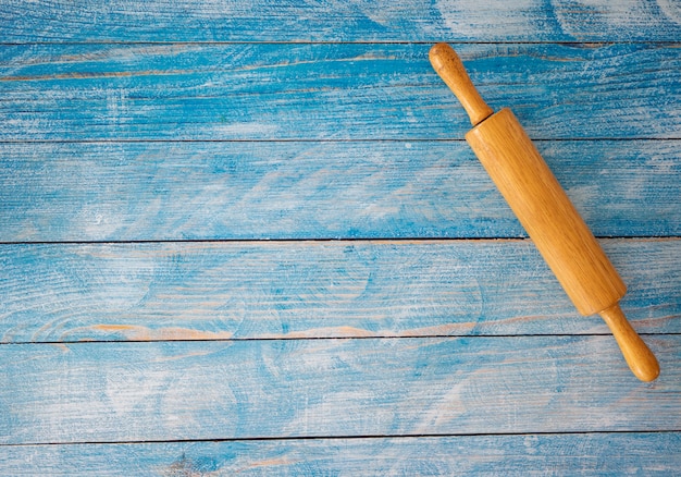 Rodillo de madera en la mesa de madera azul.