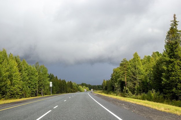 rodovia com floresta ao lado da estrada em clima nublado de outono