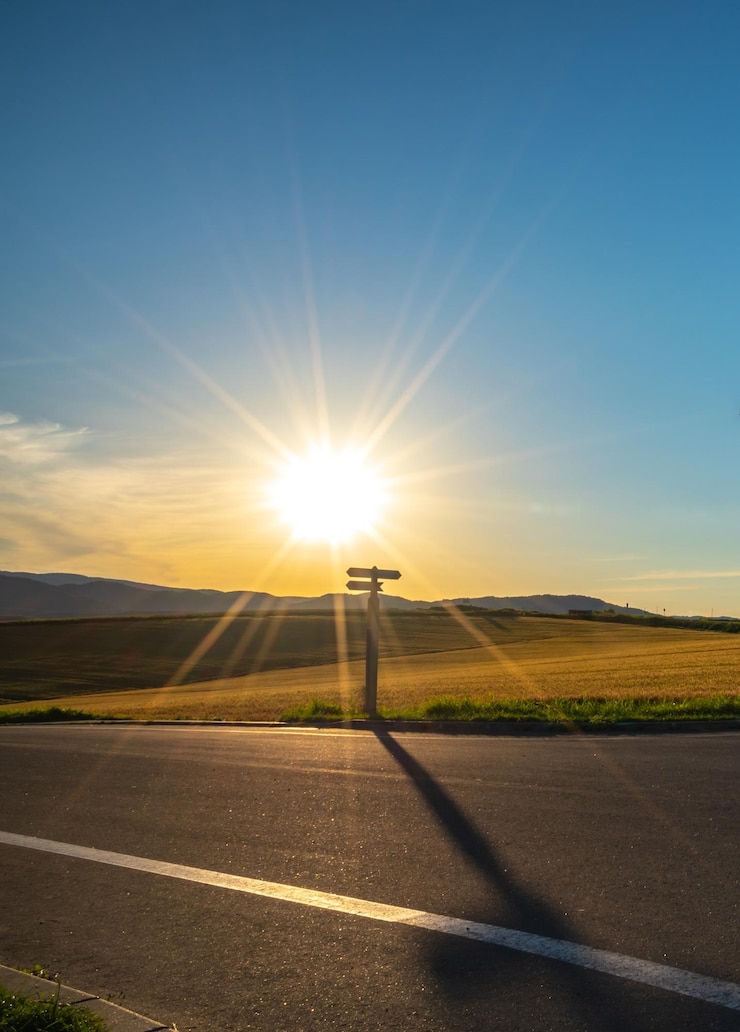 Foto rodovia de asfalto entre os campos no nascer do sol brilhante