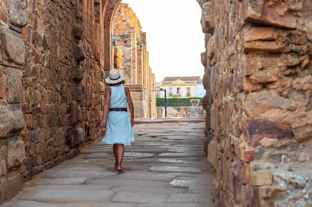 Römische Ruinen von Merida, eine junge Touristin in einem weißen Kleid, die das römische Theater und das Amphitheater besucht