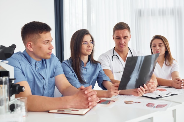 Röntgenbild der Beine Eine Gruppe junger Ärzte arbeitet im modernen Büro zusammen