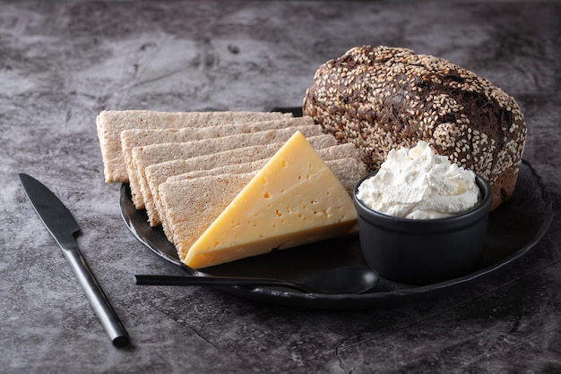 Roggenbrot Knäckebrot Käse Quark in einem Teller auf dem Küchentisch