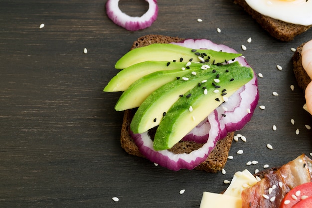 Roggenbrot mit Avocado auf hölzernem Hintergrund.