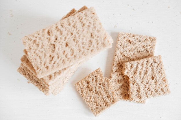 Roggenknäckebrot auf weißem Holzhintergrund. Ansicht von oben. Kopieren, leerer Platz für Text