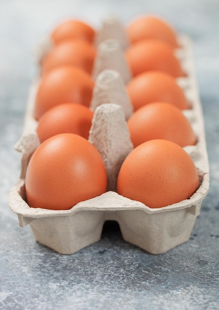 rohe braune organische Eier in einem Papierscheib auf hellem Küchenhintergrund