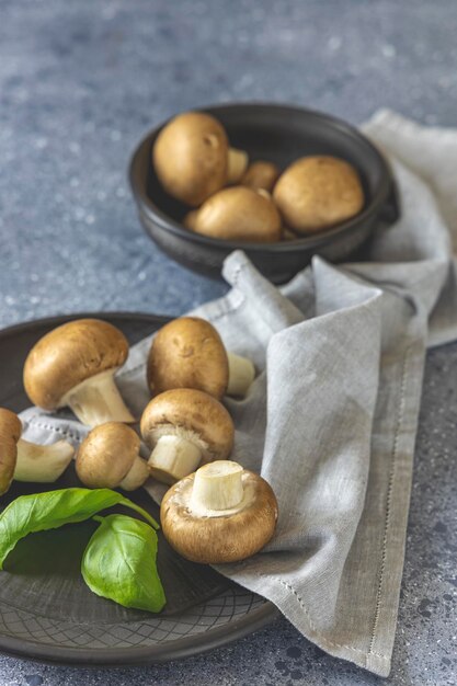 Rohe Champignons auf grauem Hintergrund, frische Champignons kochend