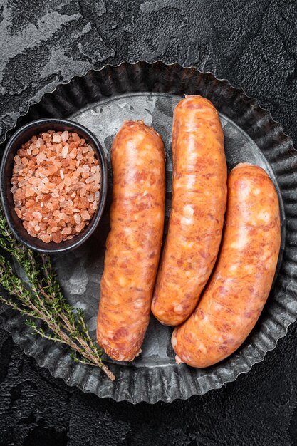 Rohe Chorizo-Würste bereit zum Kochen mit Thymian Schwarzer Hintergrund Ansicht von oben