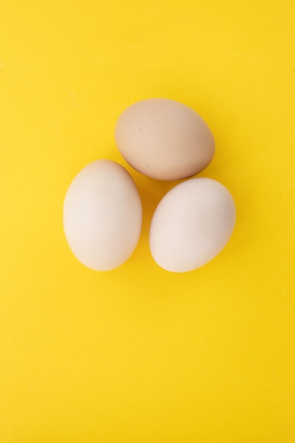 Rohe Eier auf gelbem Hintergrund