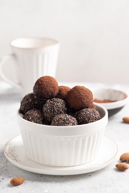 Rohe Energiebällchen aus Datteln und Chiasamen in weißer Schale Vegane Schokoladentrüffel