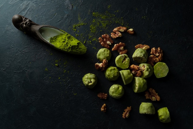 Rohe Energiebälle mit matcha Teepulver an auf dunklem Hintergrund