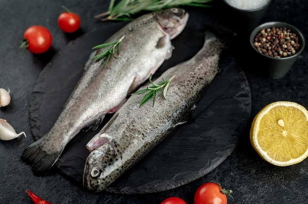 rohe Fischforelle mit kochfertigen Gewürzen auf Steinhintergrund