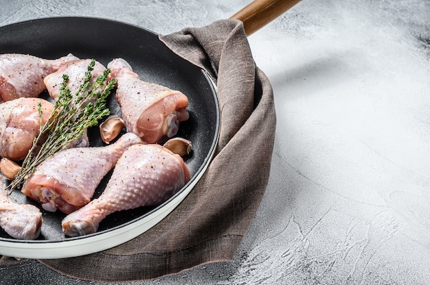 Rohe frische Hähnchenkeulen mit Gewürzen in einer Pfanne