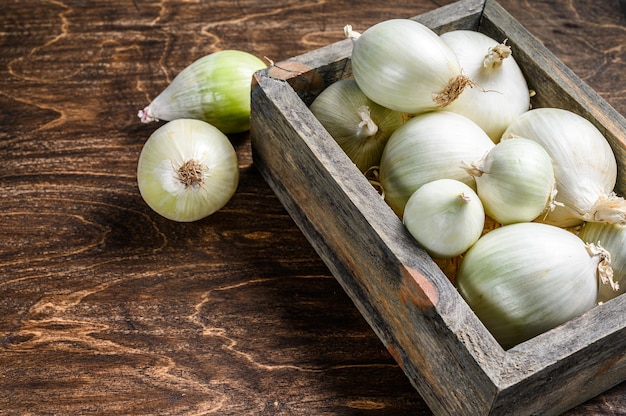 Rohe frische weiße Zwiebel in der Holzkiste.