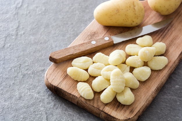 Rohe Gnocchi auf grauem Stein.