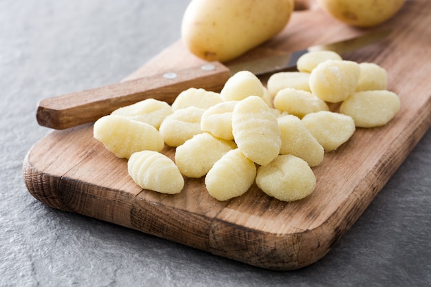 Rohe Gnocchi auf grauem Stein.