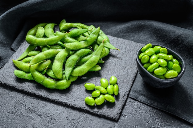 Rohe grüne Edamame-Sojabohnen auf schwarzem Hintergrund