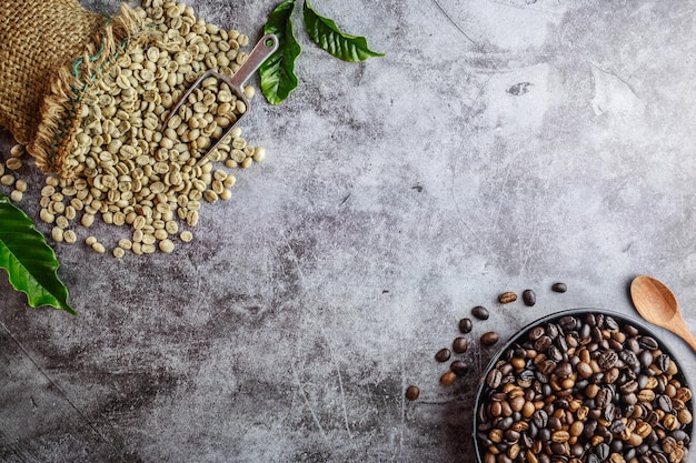 Rohe grüne ungeröstete Kaffeebohnen in braunen Säcken und geröstete Kaffeebohnen in einer Pfanne