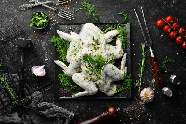 Rohe Hähnchenflügel mit Gewürzen auf einer schwarzen Platte Draufsicht Freier Kopierplatz