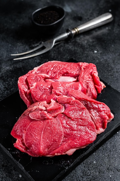 Rohe Hammelfiletsteaks vom Bein ungekochtes Lammfleisch Schwarzer Hintergrund Ansicht von oben