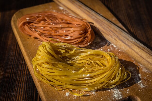 Rohe hausgemachte Pasta auf Holz