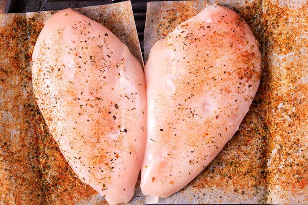 Rohe Hühnerbrust mit Gewürzen zum Braten vorbereitet