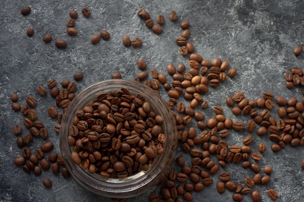 rohe kaffeebohnen im glas auf dunklem steintisch