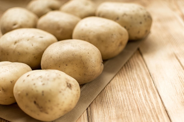 Rohe Kartoffelknollen auf einem hölzernen Hintergrund