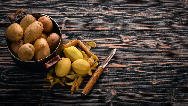 Rohe Kartoffeln auf braunem Holzhintergrund Kochen freier Platz für Text Ansicht von oben