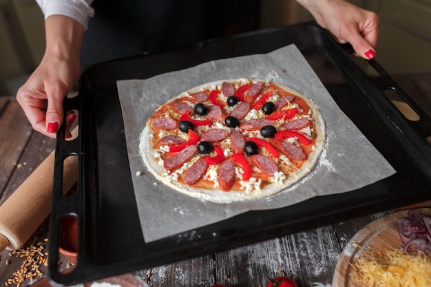 Rohe Pizza auf einem Backblech