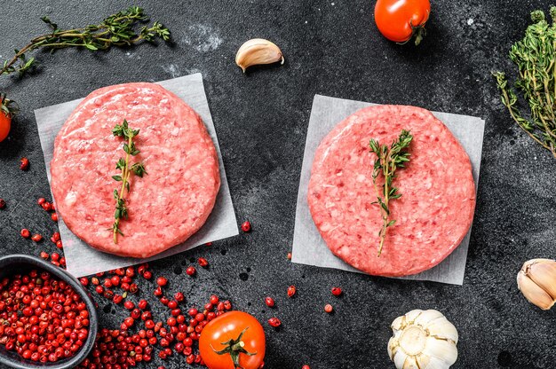 Rohe Rindfleischfleischburger auf einem dunklen Hintergrund