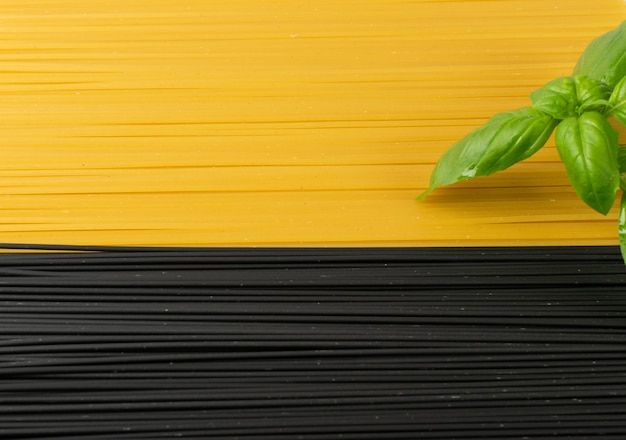 Rohe schwarze hausgemachte Spaghetti auf dunklem Hintergrund. Trockene schwarze und gelbe Eiernudelbeschaffenheit