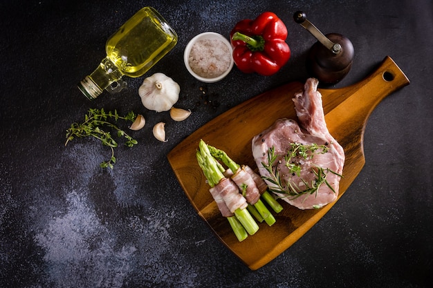 Rohe Schweinerippchen auf Schneidebrett mit Gemüse und Gewürzen, Ansicht von oben