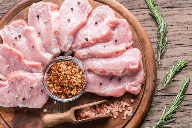 Rohe Schweinesteaks auf dem Holzbrett