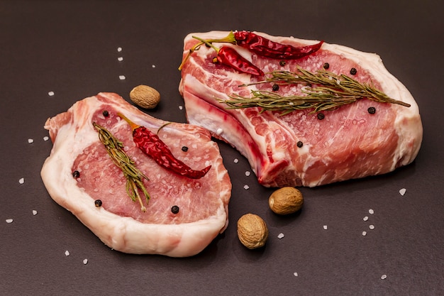 Rohe Schweinesteaks auf grauem Tisch