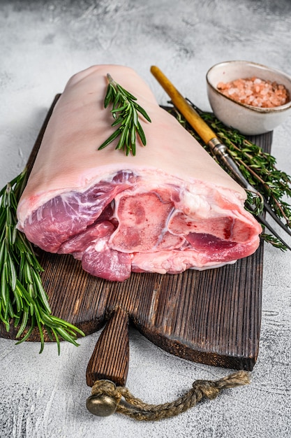 Rohe Schweinshaxe Eisbein zum Kochen mit Kräutern. Weißer Hintergrund. Ansicht von oben.